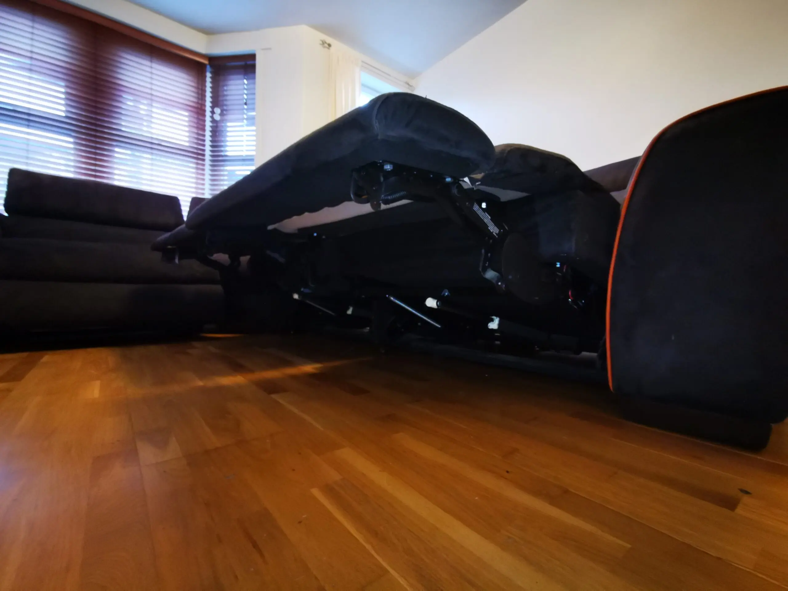 Furniture Village, corner sofa with 3 power recliner seats, black with orange piping