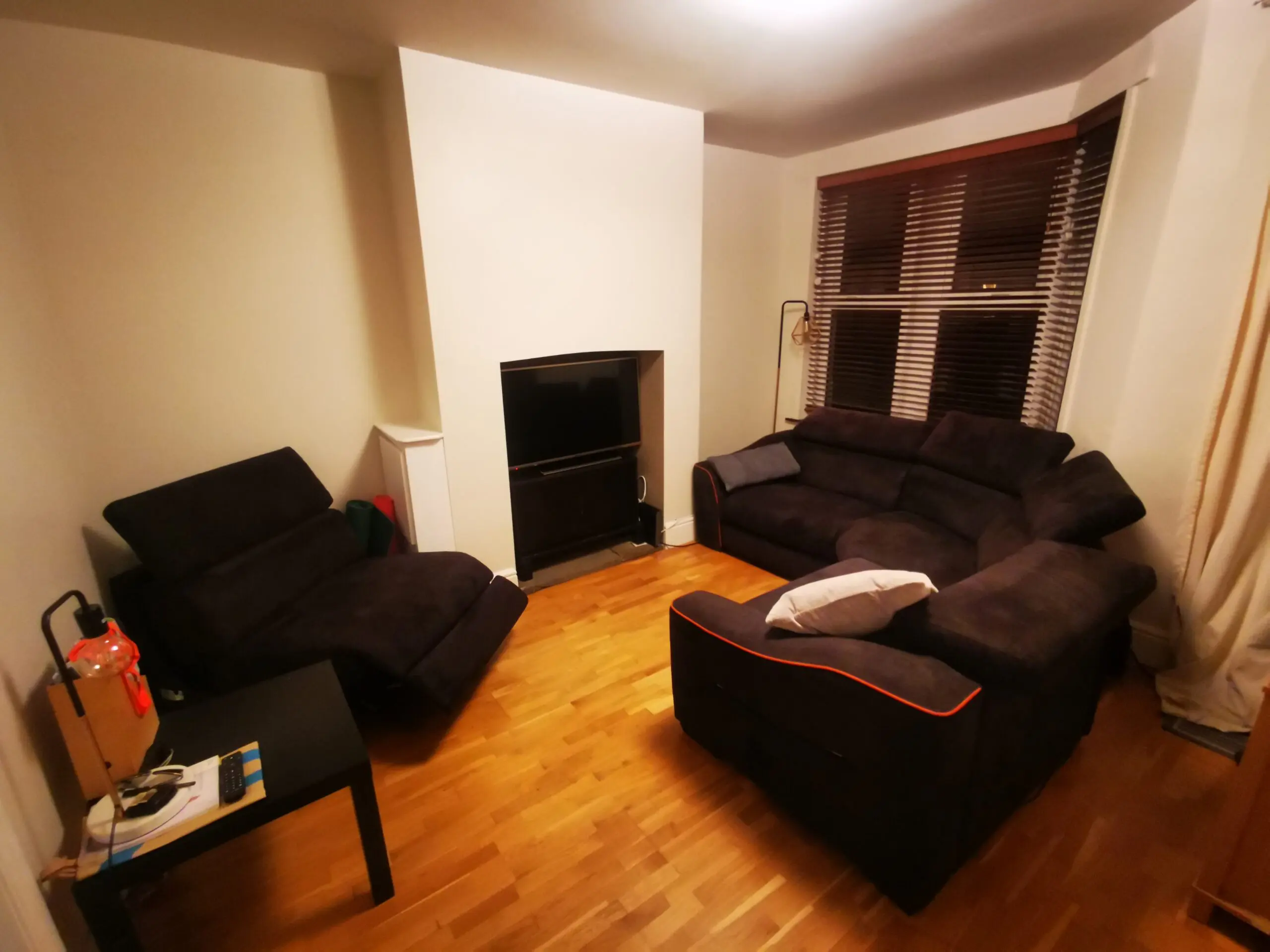 Furniture Village, corner sofa with 3 power recliner seats, black with orange piping