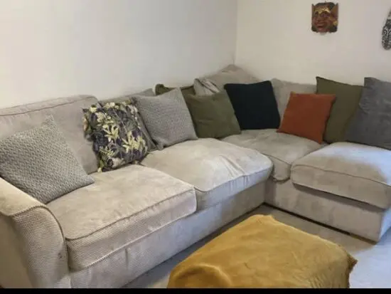 Grey corner sofa with storage footstool and cushions
