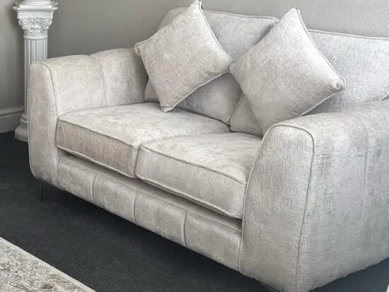 Two cream Prestine two seater sofas