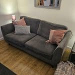 Lovely very clean 2 setter grey sofa with 2 pink/plum cushions