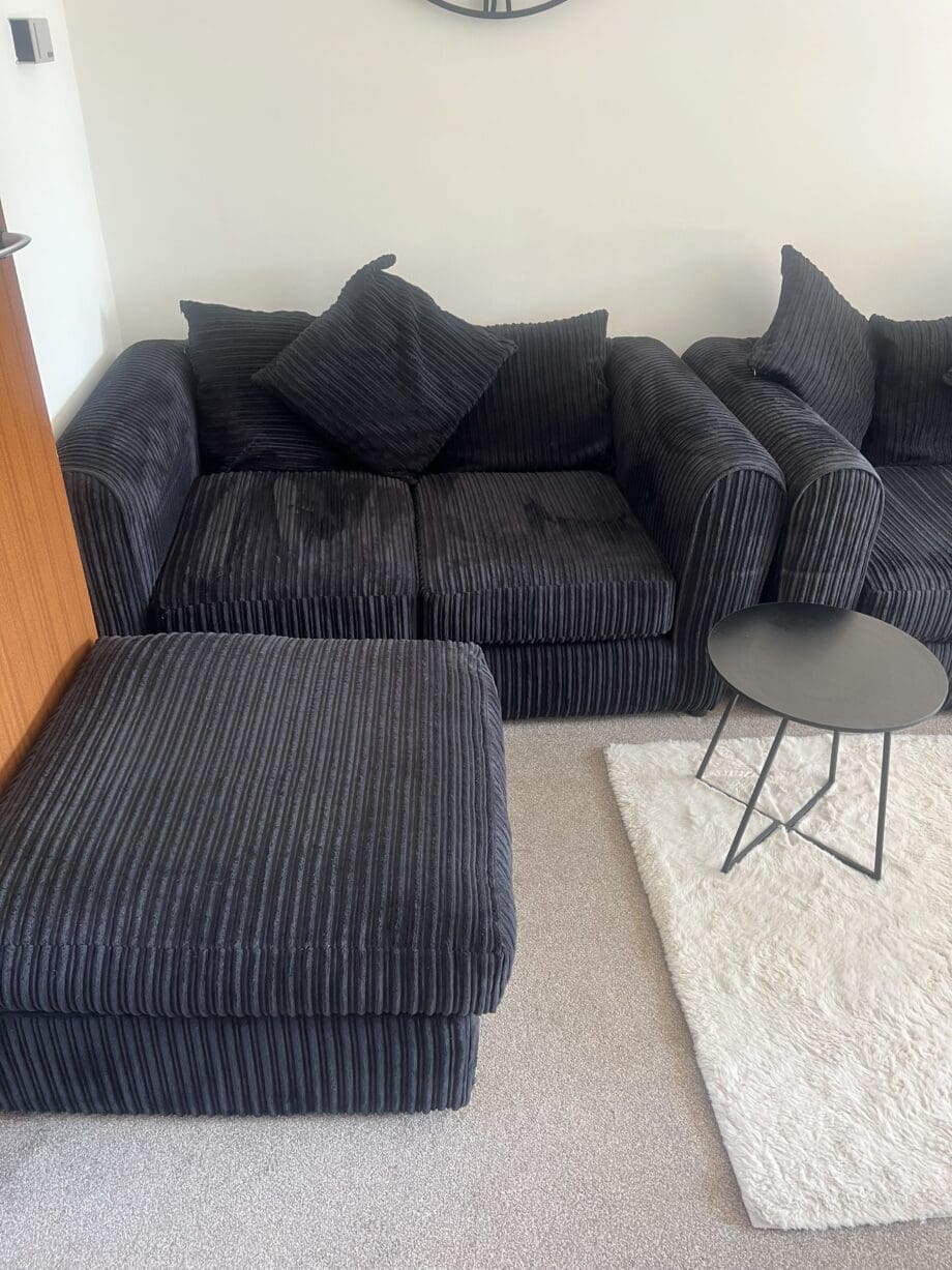 Black sofas and footstool